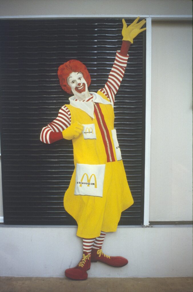 Figura recortada de palhaço fixada em painel escuro na parede — P0002 — Ronald McDonald — F016-P0002-1981-S03-D00004