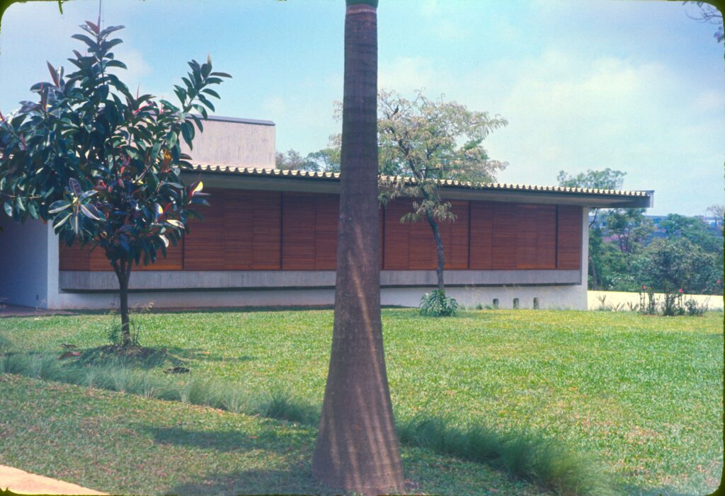 Fachada de madeira sob beiral de telhas vista do gramado — P0003 — Residência Abílio dos Santos Diniz, Cidade Jardim — F016-P0003-1972-S03-D00004