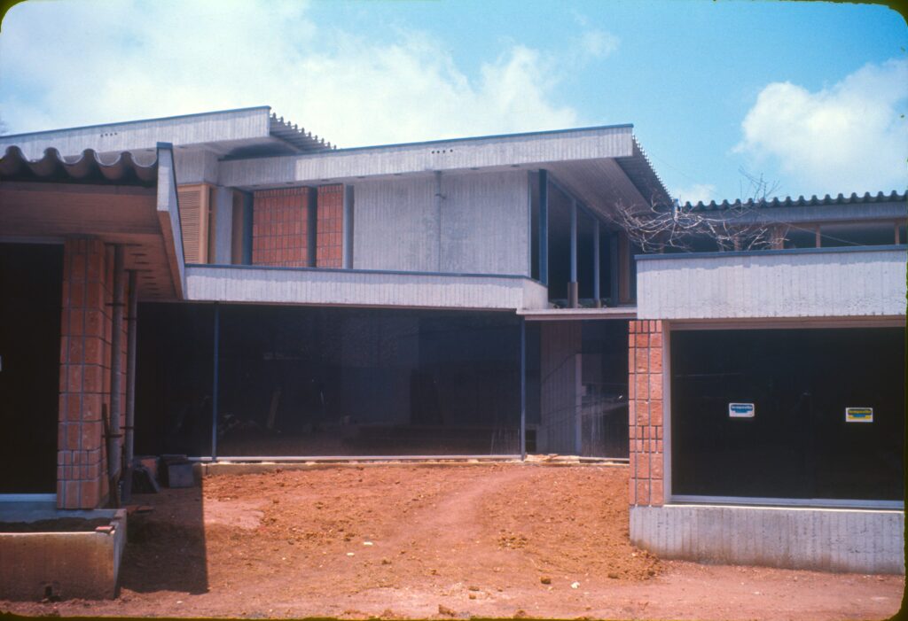 Fachada com vidros escuros e pilares de tijolo em obra — P0004 — Residência Guilherme Giorgi, Cidade Jardim — F016-P0004-1968-S03-D00011