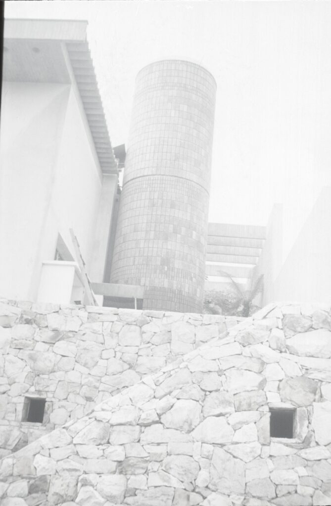 Torre cilíndrica de tijolos atrás de muro de pedra — P0004 — Residência Guilherme Giorgi, Cidade Jardim — F016-P0004-1968-S03-D00012