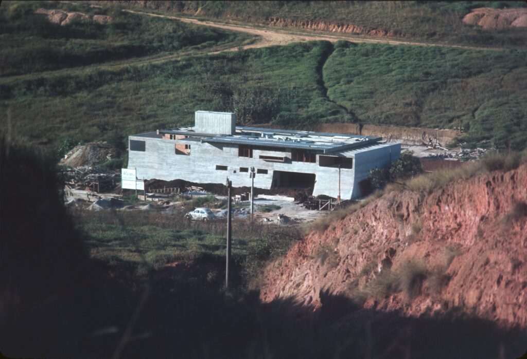 Obra vista do alto, volume horizontal de concreto sobre barranco de terra vermelha — P0006 — Residência Luiz Carlos Bresser Pereira, Jardim Guedala — F016-P0006-1967-S03-D00006