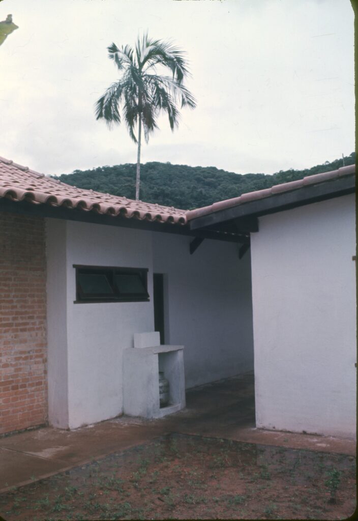 Lateral caiada com janela de madeira e tanque de concreto projetado da parede — P0007 — Residência Luiz França, Praia do Lázaro, Ubatuba — F016-P0007-1965-S03-D00011