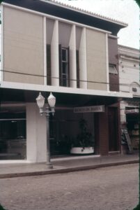 Fachada com pilares inclinados e letreiro no térreo — P0009