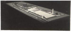 Maquete de complexo industrial com galpões de cobertura shed, chaminé e acessos viários — P0015 — SESI — Ribeirão Preto