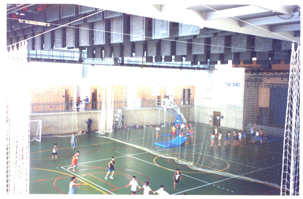 Quadra poliesportiva coberta com crianças jogando, vista de cima, estrutura metálica e redes de proteção ao redor da quadra — P0131 — SESC - Piracicaba — F009-P0131-0000-S03-D00042