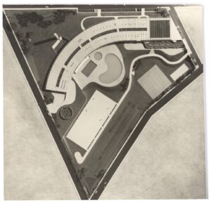 Vista aérea de conjunto arquitetônico com edifício curvo, piscina em formato irregular, quadras esportivas e áreas verdes, delimitado por via em formato triangular — P0015 — SESI — Ribeirão Preto