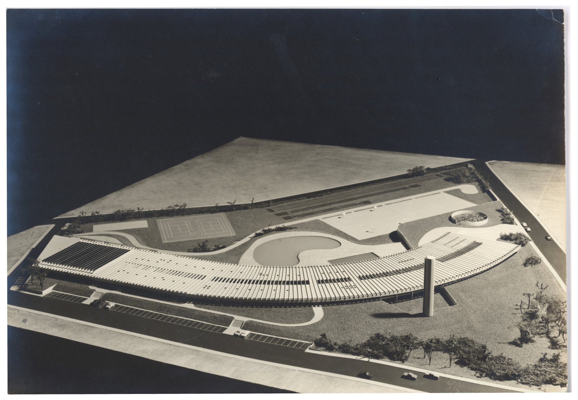 Vista aérea de maquete de complexo esportivo com arquibancadas curvas, piscina, quadras de tênis e pista — P0015 — SESI — Ribeirão Preto — F009-P0015-1973-S03-D00014