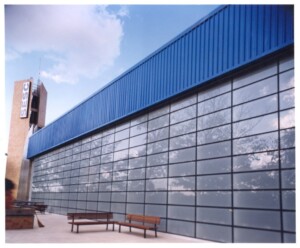 Vista ascendente da fachada de vidro e cobertura metálica azul de edifício do SESC — P0131