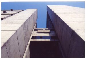 Vista ascendente de edifício em concreto aparente, destacando volumes em balanço e textura das formas — P0018 — Correios — Sede Regional e Centro de Triagem