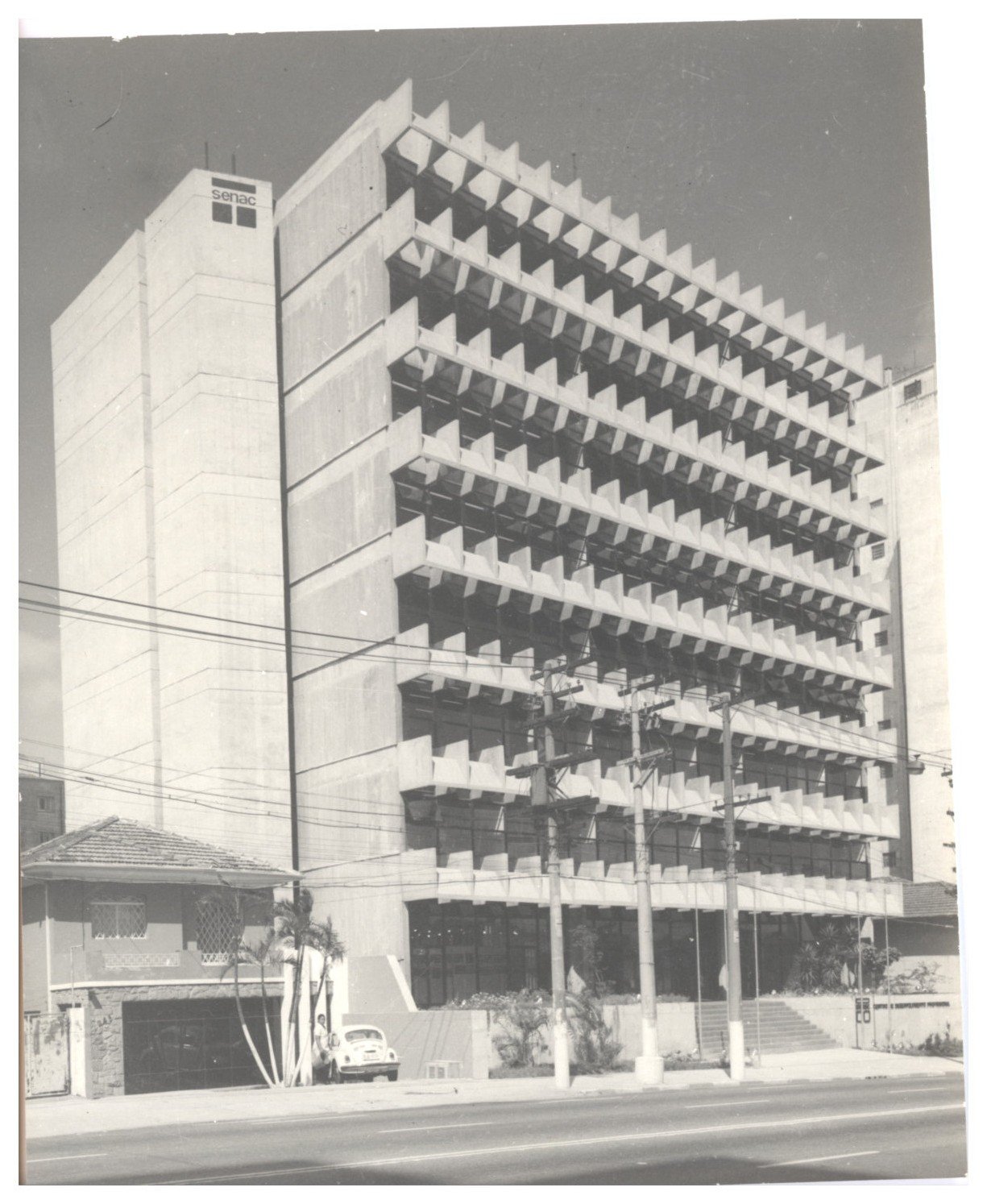Vista da fachada de edifício com brises de concreto em padrão triangular repetitivo, com letreiro "Senac" visível na base — P0112 — SENAC — Av. Francisco Matarazzo — F009-P0112-1972-S03-D00004