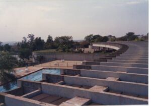 Vista de conjunto arquitetônico com terraços escalonados de concreto, piscina e edificação curva ao fundo — P0015 — SESI — Ribeirão Preto