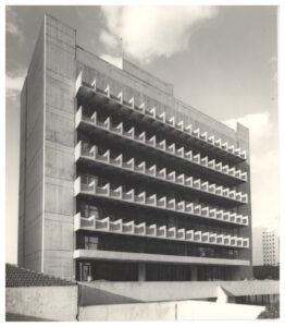 Vista em perspectiva de edifício modernista de múltiplos pavimentos, destacando fachada com elementos de proteção solar (brises) em concreto aparente, dispostos em padrão geométrico repetitivo — P0112 — SENAC — Av. Francisco Matarazzo