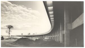 Vista inferior de estrutura curva de concreto, com pilares e vigas se estendendo ao longo de grande extensão — P0015 — SESI — Ribeirão Preto
