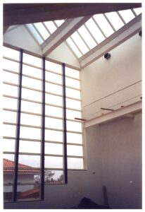 Vista interna de ambiente com claraboia/painel translúcido em grade metálica e cobertura inclinada, refletindo telhado externo — P0131 — SESC - Piracicaba