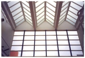 Vista interna de clarabóia em duas águas com estrutura metálica/madeira aparente e painel de vidro vertical — P0131 — SESC - Piracicaba