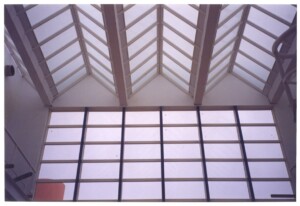 Vista interna de clarabóia em duas águas com estrutura metálica/madeira aparente e painel de vidro vertical — P0131 — SESC - Piracicaba