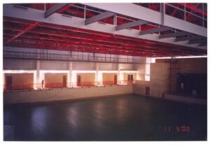 Vista interna de edificação em fase de acabamento, mostrando estrutura metálica do telhado, mezanino e piso de grandes dimensões — P0131