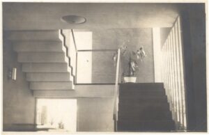 Vista interna de escada com degraus em balanço, guarda-corpo de vidro e teto com ripas, em ambiente de arquitetura modernista — P0001 — Residência Aecio Aeouche de Toledo