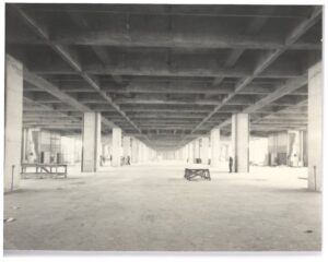 Vista interna de laje nervurada de concreto em construção, com fileiras de pilares e andaimes ao fundo — P0018 — Correios — Sede Regional e Centro de Triagem
