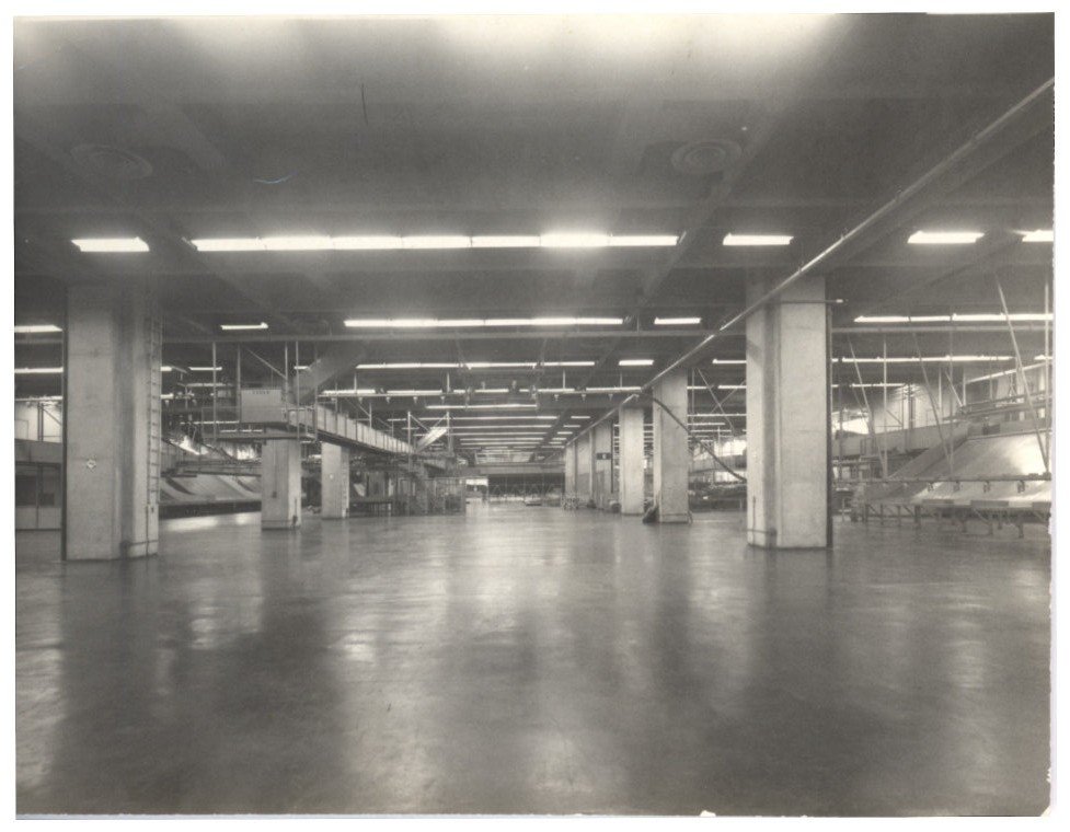 Vista interna de nave industrial mostrando estrutura de vigas de concreto e sistema de iluminação — P0018 — Correios — Sede Regional e Centro de Triagem — F009-P0018-1975-S03-D00011