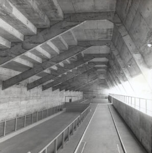 Vista interna de passagem em concreto aparente com vigas transversais e corrimãos laterais — P0060 — SESI — Marília