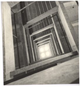 Vista interna de poço estrutural em concreto, fotografado de cima, com efeito de profundidade até abertura iluminada no fundo — P0112 — SENAC — Av. Francisco Matarazzo