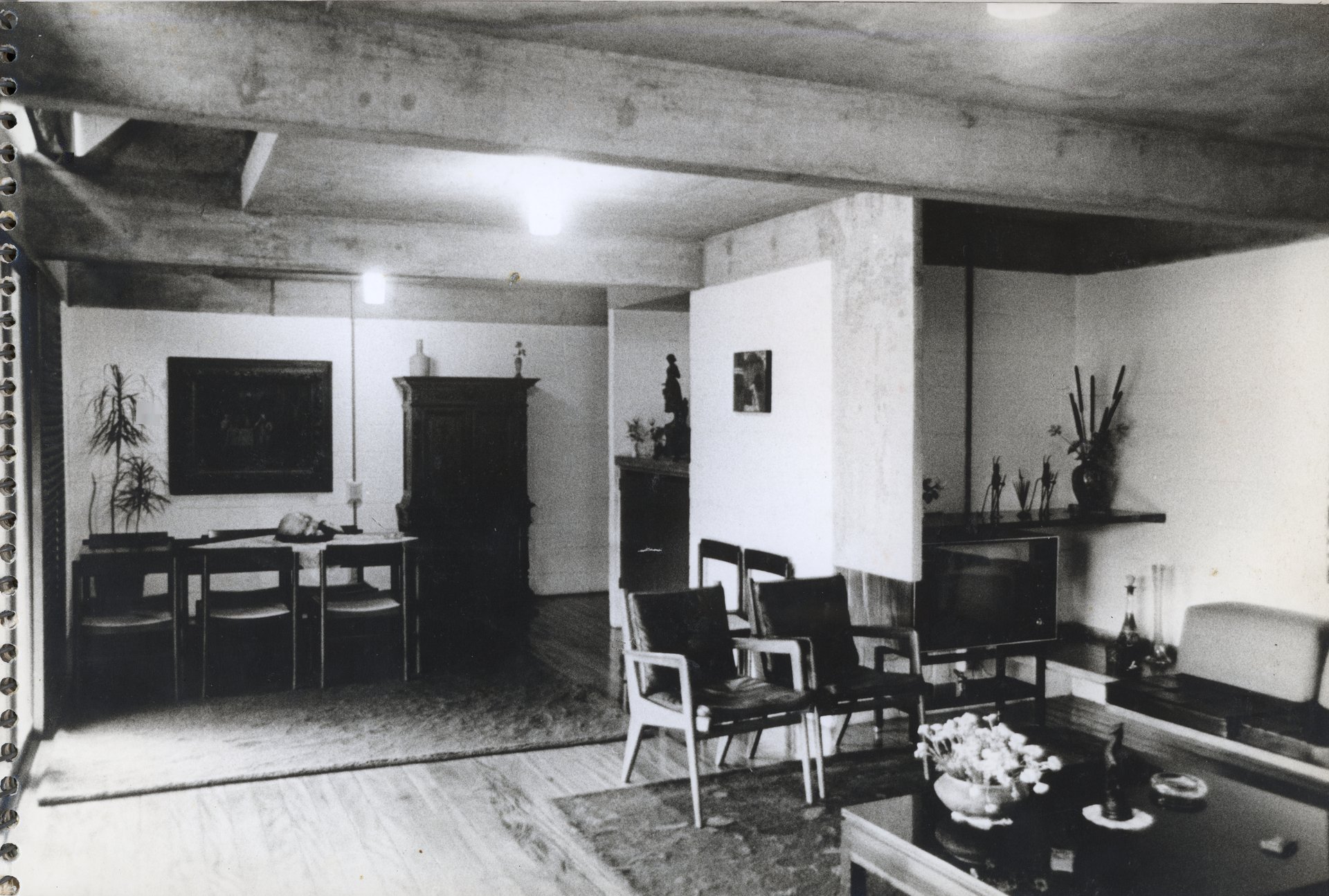 Vista interna de sala de estar e jantar integradas, com teto de vigas de concreto aparente, mobiliário diverso e objetos decorativos — P0001 — Residência Teresa Martino — F001-P0001-0000-S03-D90004